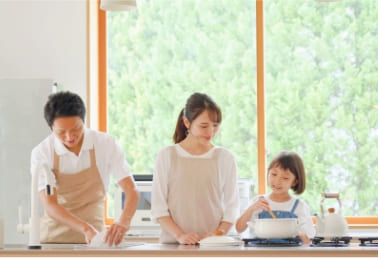 キッチンで夫婦がシステムキッチンを説明を受けている様子